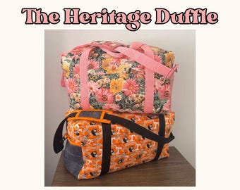 May include: Two duffle bags stacked on a wooden surface. The top bag has a floral pattern with pink straps. The bottom bag is orange with a repeating dog graphic and black straps. Text at the top reads "The Heritage Duffle."