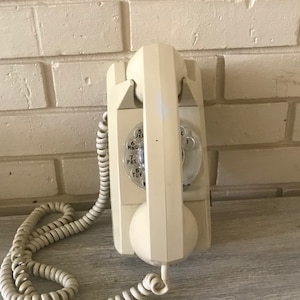Vintage telephone, Gte,Wall mount, rotary dial, almond color, telephone, comes with a wall mount.