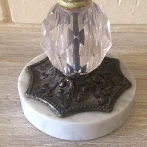 May include: A vintage glass and marble candle holder with a faceted glass top and a decorative metal base.