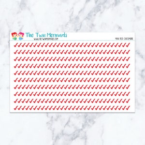 May include: A sheet of stickers featuring numerous red checkmarks. The text "The Twin Mermaids" and "www.thetwinmermaids.com" are printed at the top, along with "MINI RED CHECKMARK". The stickers are arranged in neat rows and columns.