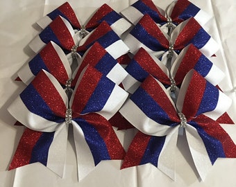 May include: Set of ten red, white and blue glitter cheer bows with rhinestones.
