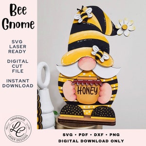 Könnte beinhalten: Eine Holz-Gnom-Figur mit einem schwarz-gelb gestreiften Hut, die ein Honigglas mit der Aufschrift "Honey" hält. Der Gnom hat einen weißen Bart und ein gelbes Gesicht. Der Gnom steht auf einem Holzsockel. Der Gnom ist mit Bienen und Blumen verziert.