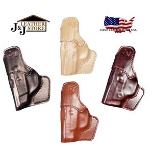 May include: Four leather gun holsters in various colors: black, tan, brown, and burgundy. Each holster is stamped with "J & J" and the image includes the text "Leather Store" and "Hand Crafted in the USA".
