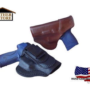 May include: Two leather gun holsters, one brown and one black, each holding a blue handgun. The holsters are shown against a white background. The image includes the text "J&J Leather Store" and a US flag graphic with the text "Hand Crafted in the USA."