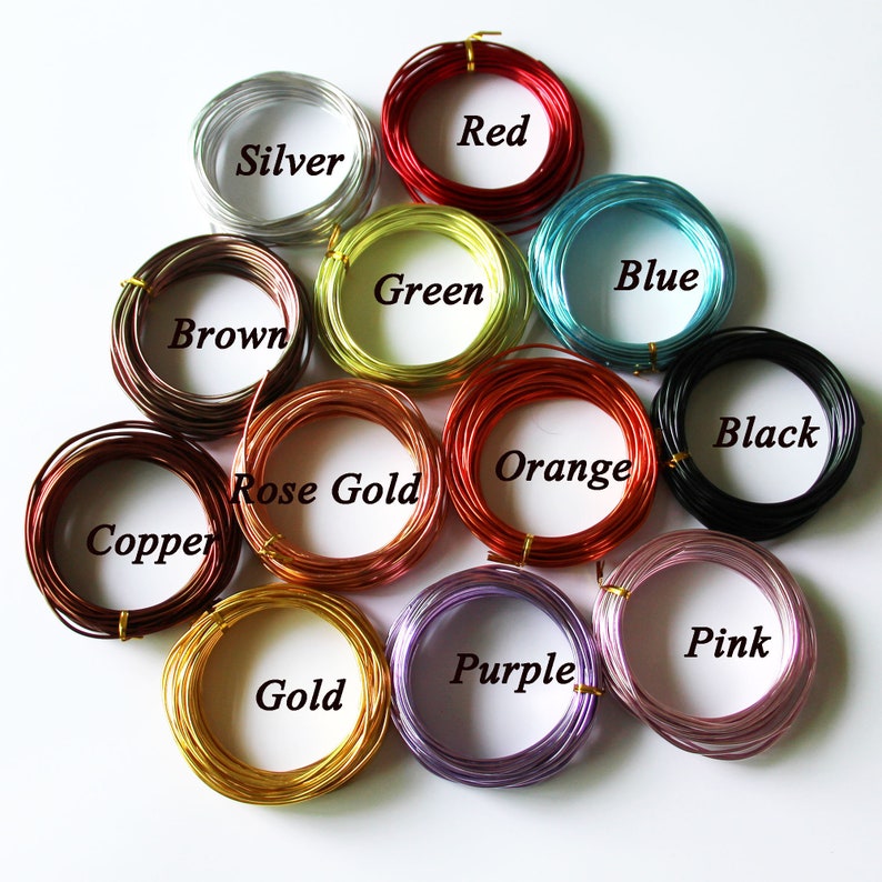 May include: A collection of coiled wire in various colors, including silver, red, blue, black, and gold. Each coil is labeled with its color name. The wires are likely for crafting or jewelry making.