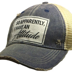 May include: A blue and beige distressed trucker hat with a white patch that reads "So Apparently, I Have An Attitude".