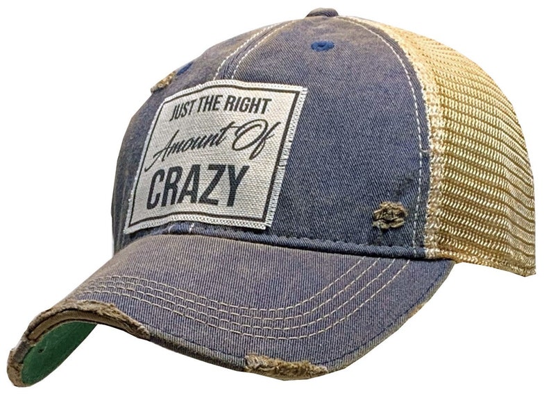 May include: A blue and beige distressed trucker hat with a white patch that reads "Just the Right Amount of Crazy".