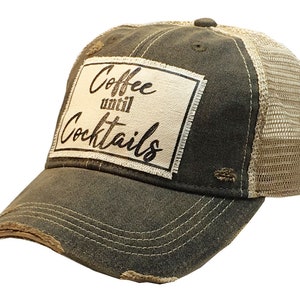 May include: A dark green and beige distressed trucker hat with a white patch that reads "Coffee until Cocktails".