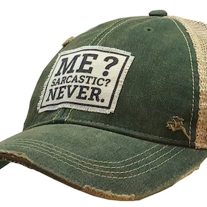 May include: A green and tan trucker hat with a distressed look. The hat has a patch on the front that says "ME? SARCASTIC? NEVER."