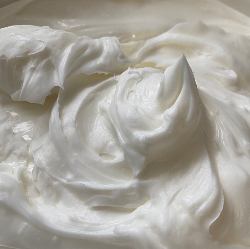 May include: Close-up of a white, creamy substance with a smooth, whipped texture.
