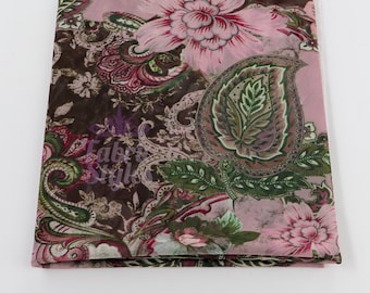 May include: A folded piece of fabric with a floral and paisley pattern. The fabric features large pink flowers, green leaves, and paisley shapes against a brown and pink background. The text "Fabric Style" is visible in the image.