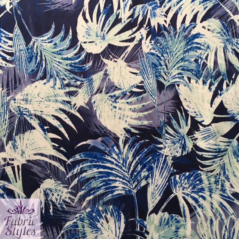 May include: Fabric with a tropical leaf pattern in shades of blue, white, and teal. The design features large palm leaves and other foliage against a dark blue background. The Fabric Styles logo is in the bottom left corner.