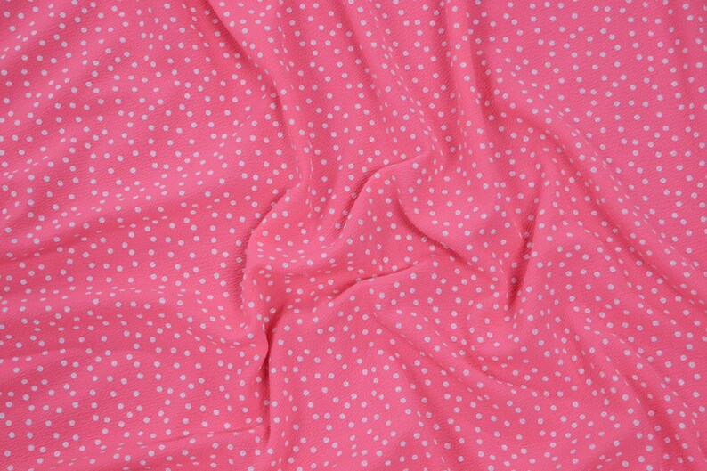 Peut inclure: Tissu rose &agrave; pois blancs. Le tissu est froiss&eacute; et a une texture douce.