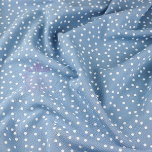 Peut inclure: Un gros plan sur un tissu bleu avec des pois blancs. Le tissu est froiss&eacute; et a une surface textur&eacute;e.