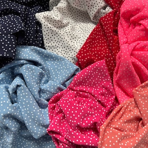 Peut inclure: Gros plan sur diff&eacute;rents tissus &agrave; pois de diff&eacute;rentes couleurs, notamment bleu, rose, rouge et blanc.