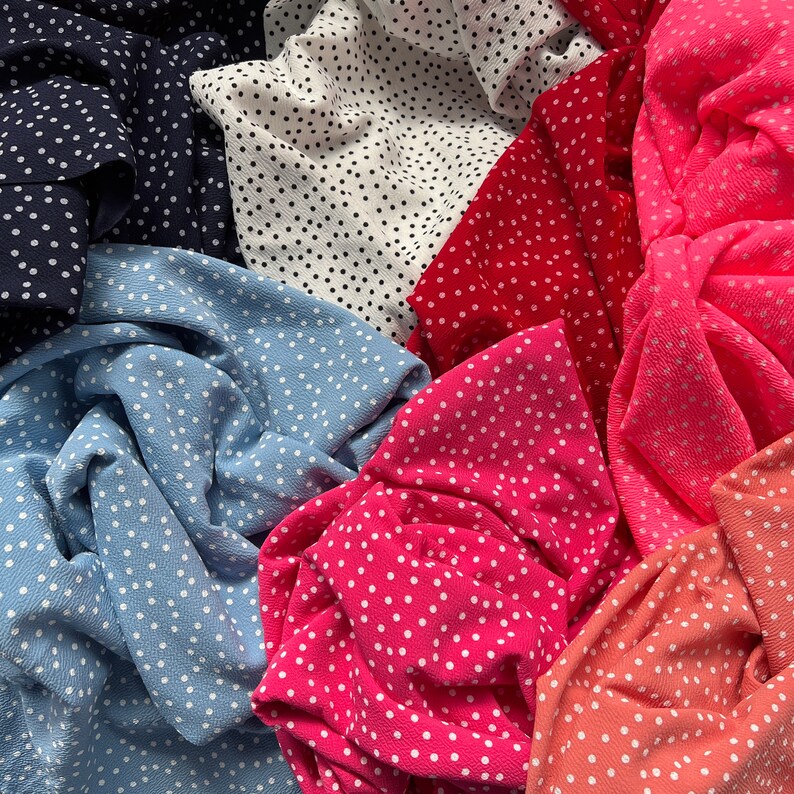 Peut inclure: Gros plan sur diff&eacute;rents tissus &agrave; pois de diff&eacute;rentes couleurs, notamment bleu, rose, rouge et blanc.
