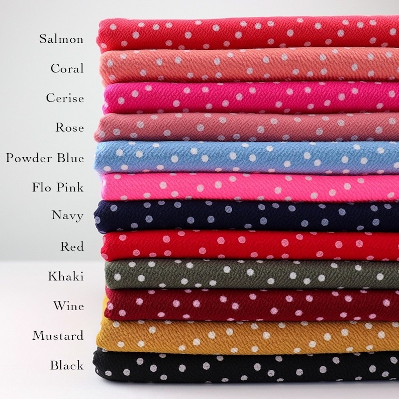 Peut inclure: Un empilement de 12 &eacute;chantillons de tissu avec des pois blancs sur des fonds de couleurs diff&eacute;rentes. Les couleurs sont le saumon, le corail, le cerise, la rose, le bleu poudre, le rose flo, le marine, le rouge, le kaki, le vin, la moutarde et le noir.