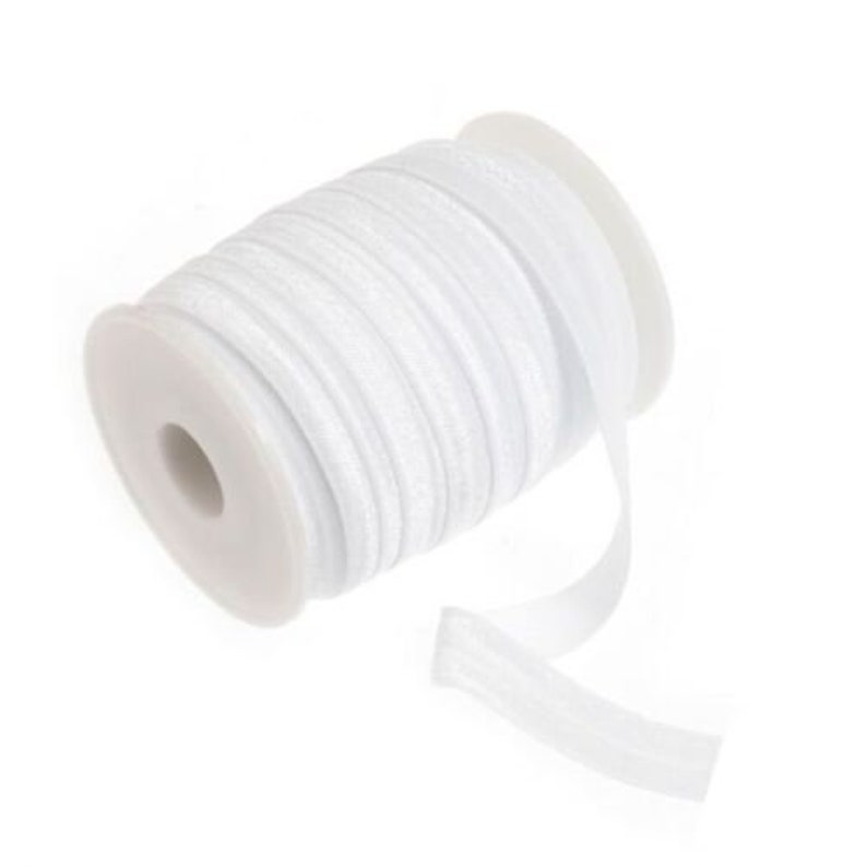 May include: A spool of white elastic ribbon with a slight shimmer. The ribbon is wound around a white plastic spool.