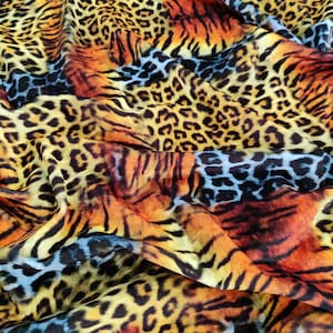 Peut inclure: Un tissu vibrant avec un imprimé animalier mixte. Le motif présente une combinaison de taches de léopard et de rayures de tigre dans des tons de jaune, d'orange et de noir. Le tissu a un aspect fluide et drapé.