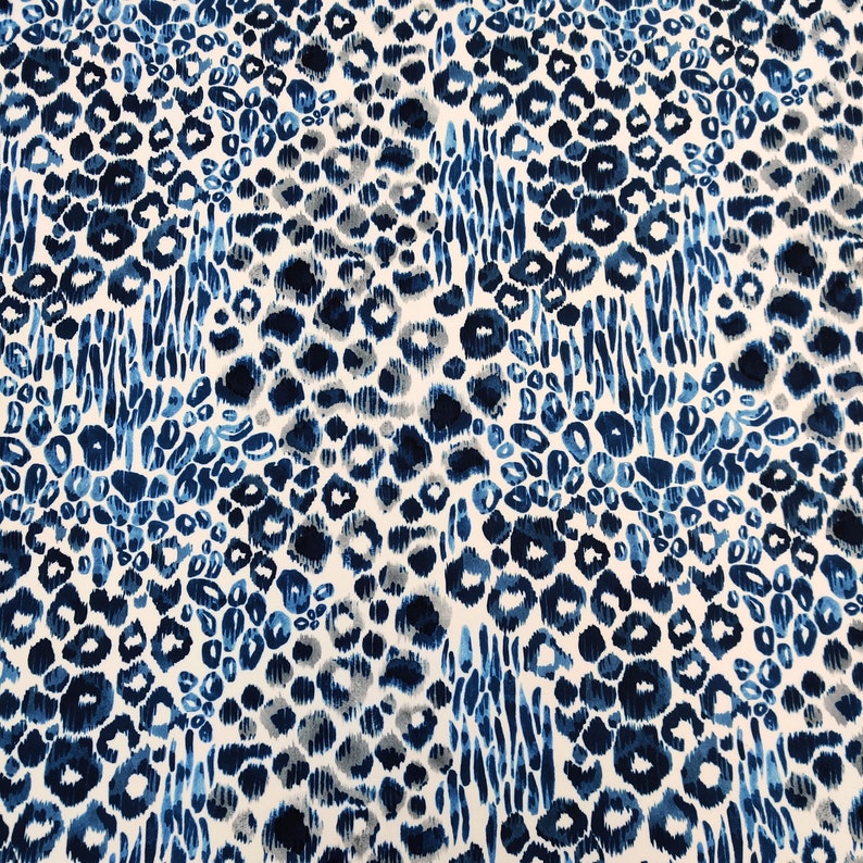 May include: A fabric with a repeating pattern of blue and gray leopard spots and vertical stripes on a white background. The spots vary in size and shade, creating a textured appearance. The design is suitable for apparel or home decor.