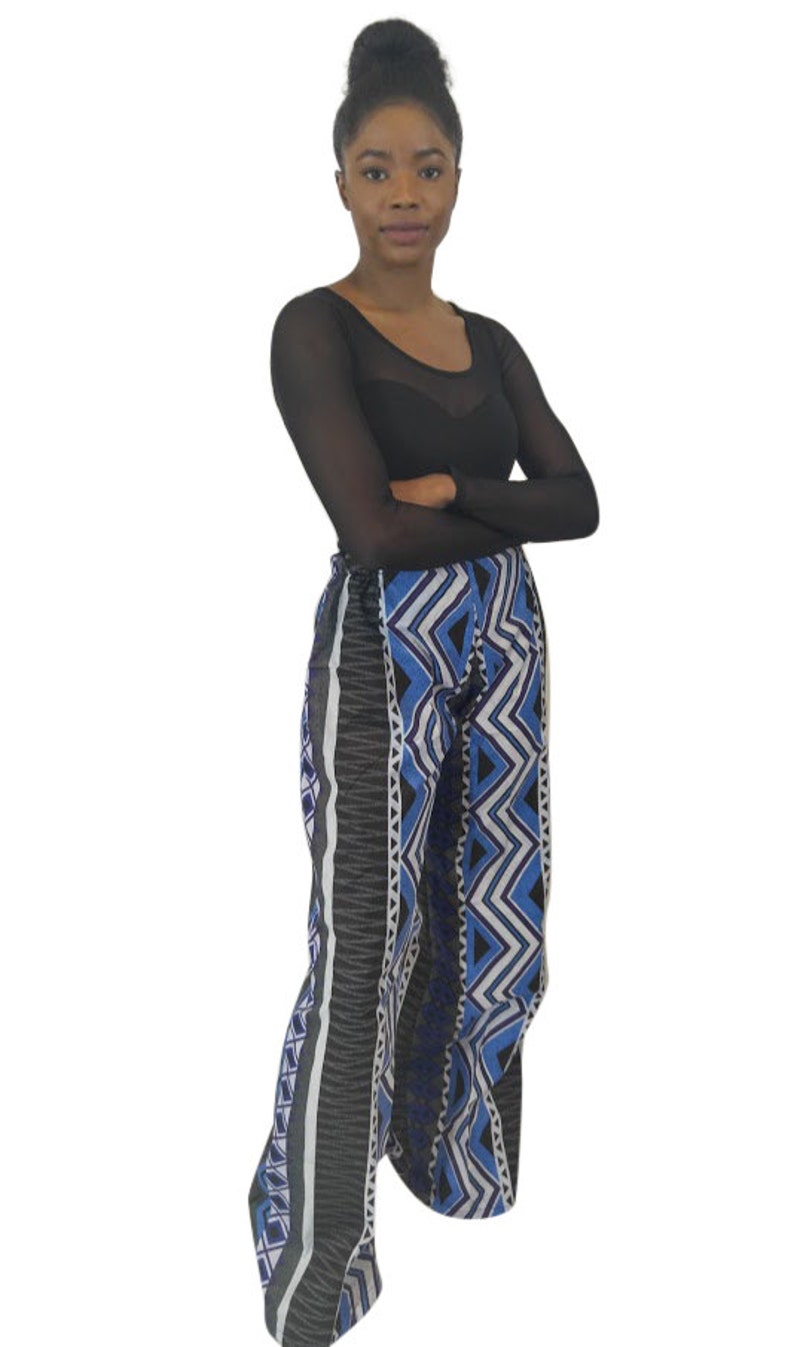 Handmade African wide leg pants for women, featuring authentic Ankara print, elastic waistband, and zip closure. Stylish high waist palazzo trousers with pockets on both sides for comfort and convenience. Perfect for casual outings, work, cultural events, festivals, and vacations. Flowy, breathable, and versatile African print pants designed by OLUDAN Clothing. Pair with tops, blouses, or African accessories for a chic look.