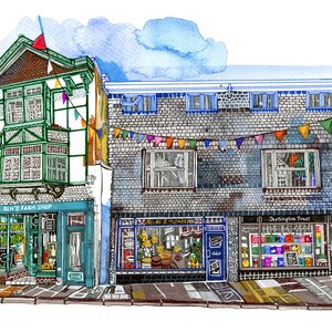 Puede incluir: Ilustración en acuarela de una escena callejera con tres tiendas. "Ben's Farm Shop" tiene una fachada verde y blanca. Las otras tiendas son "Seeds & Things" y "Darlington Trust". Guirnaldas de colores cuelgan sobre las tiendas.