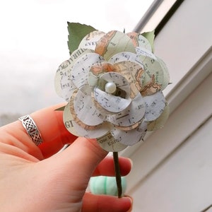 Boutonniere di carta realizzata con mappa e spartiti musicali