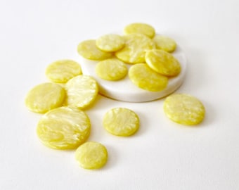 Vintage pearlised marbled lemon yellow mixed size buttons. Various size mixed light yellow pearlised buttons. 15 yellow buttons in 4 sizes.