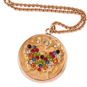 May include: A gold-toned pendant necklace with a round, floral-patterned locket. The locket features a butterfly design made of colorful gemstones. The chain is also gold-toned.