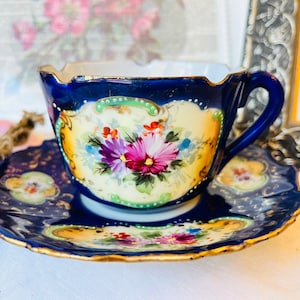 Antike unmarkierte Porzellan-Teetasse und Untertasse in Kobaltblau mit Gold, rosa Blumen, handbemalter, ausgebogter Rand