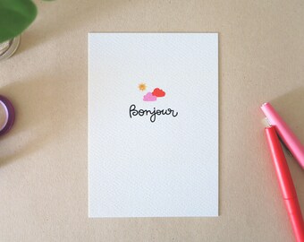 Greeting card printed with happy sun and clouds and HELLO message in a personal lettering