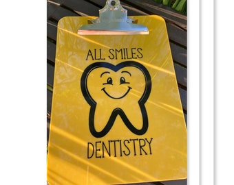 May include: Yellow clipboard with a black tooth graphic and the text "All Smiles Dentistry".
