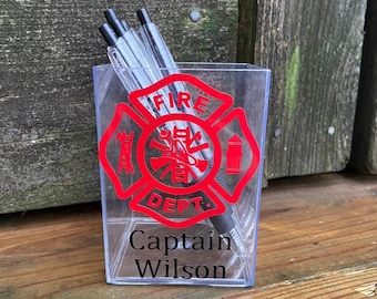 May include: A clear plastic desk organizer with a red fire department logo and the text "Captain Wilson".