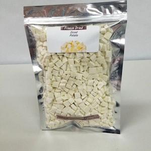 May include: A silver resealable bag filled with freeze-dried diced potato. The bag has a label that reads "Freeze Dried Diced Potato".