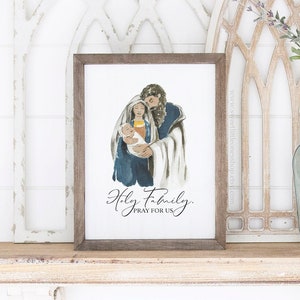 May include: A watercolor painting of the Holy Family, Mary, Joseph, and baby Jesus. The painting is framed in a brown wood frame and has the text "Holy Family, Pray for Us" written below the image.