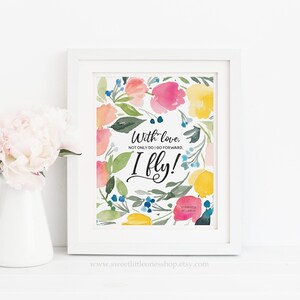May include: A watercolor print with a floral design in shades of pink, yellow, and blue. The print features the quote "With love, not only do I go forward, I fly!" and the text "St. Therese of Lisieux".