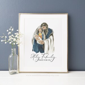 May include: A watercolor painting of the Holy Family, Mary, Joseph, and baby Jesus. The painting is in shades of blue, brown, and white. The text "Holy Family, Pray for Us" is written below the image.