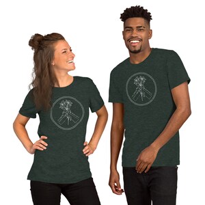 May include: Two people wearing dark green t-shirts. Each shirt features a white circular design with a floral illustration and the text "ST JAMES PENINSULA". The shirts are made of a soft material.