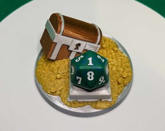 May include: A green and blue 20-sided die with white numbers sits on a silver base with a gold coin design. A brown wooden treasure chest sits behind the die.