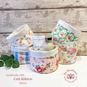 May include: Four fabric storage baskets with floral patterns in pink, green, blue, and white. The baskets are handmade with Cath Kidston fabrics. The text "Scandilicious" and "Wishing you a happy Easter" is on a red and white heart-shaped design.