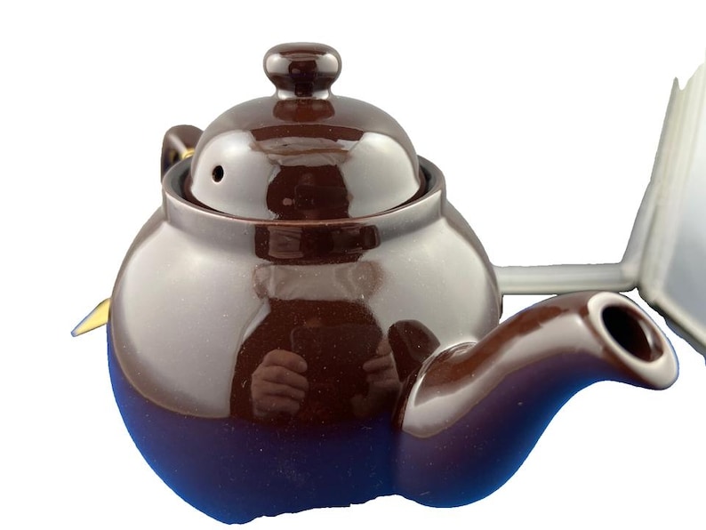 Puede incluir: Una tetera de cer&aacute;mica marr&oacute;n con cuerpo redondeado, boquilla curva y tapa con peque&ntilde;o pomo. La tetera tiene un acabado brillante y est&aacute; dise&ntilde;ada para preparar t&eacute;. Es un dise&ntilde;o cl&aacute;sico.