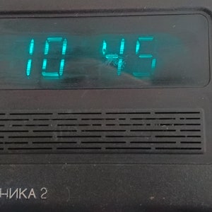 May include: A black and blue digital clock showing the time 10:45 in bright teal digits. The clock has a rectangular design with a speaker grill and the text "ЭЛЕКТРОНИКА 2" printed below the display.