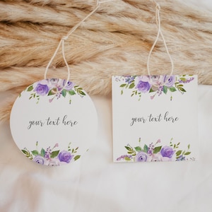 May include: Two round gift tags with purple floral designs and the text "your text here".