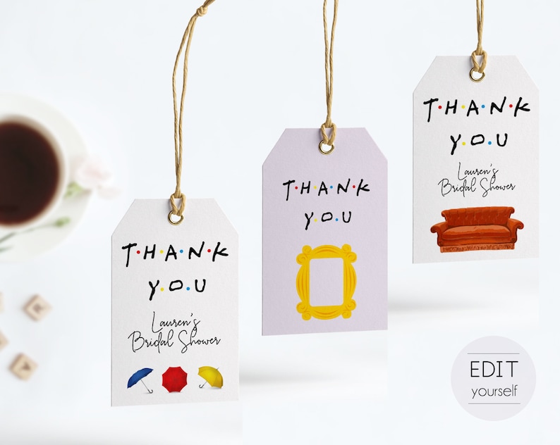 May include: Three purple and white thank you tags with the text "THANK YOU" in black with colorful dots. Each tag has a different image: a yellow frame, a brown couch, and three colorful umbrellas. The text "Lauren's Bridal Shower" is on two of the tags.