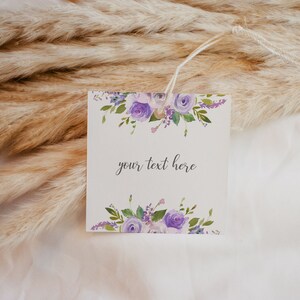 May include: A white gift tag with a purple floral design and the text "your text here".