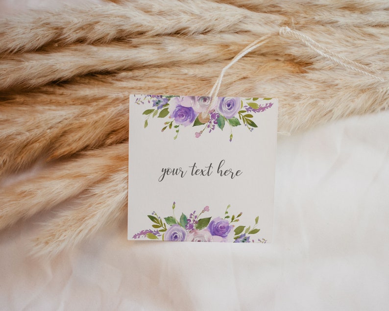 May include: A white gift tag with a purple floral design and the text "your text here".