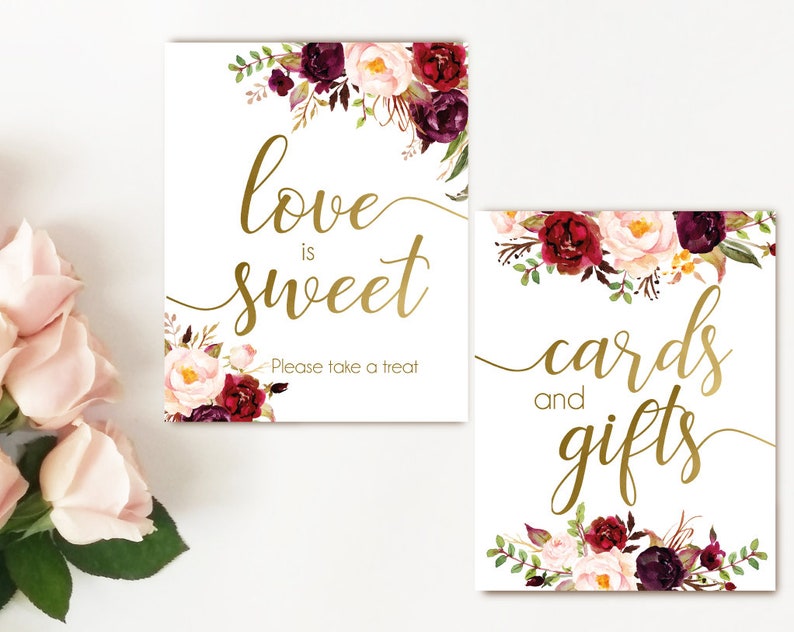 K&ouml;nnte beinhalten: Zwei druckbare Schilder mit einem Blumendesign in den Farben Burgunderrot, Rosa und Gr&uuml;n. Der Text auf den Schildern lautet "Liebe ist s&uuml;&szlig;, bitte nimm einen Leckerbissen" und "Karten und Geschenke".
