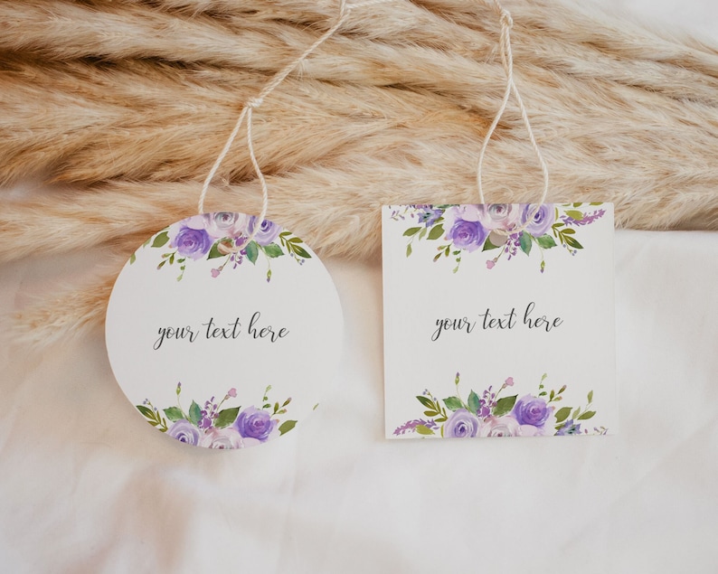 May include: Two round gift tags with purple floral designs and the text "your text here".