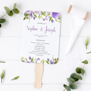 以下が含まれることがあります： 紫と緑の花柄の結婚式プログラムファンで、"Sophia & Josephの結婚式"と日付"2021年7月15日土曜日"の文字が書かれています。