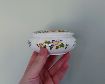 Rond sieradendoosje met cottage-tuinmotief van Aynsley Jewellery, gemaakt van fijn porselein (bone china), vervaardigd in Engeland. Een vintage verzamelobject met cottage-tuinmotief.